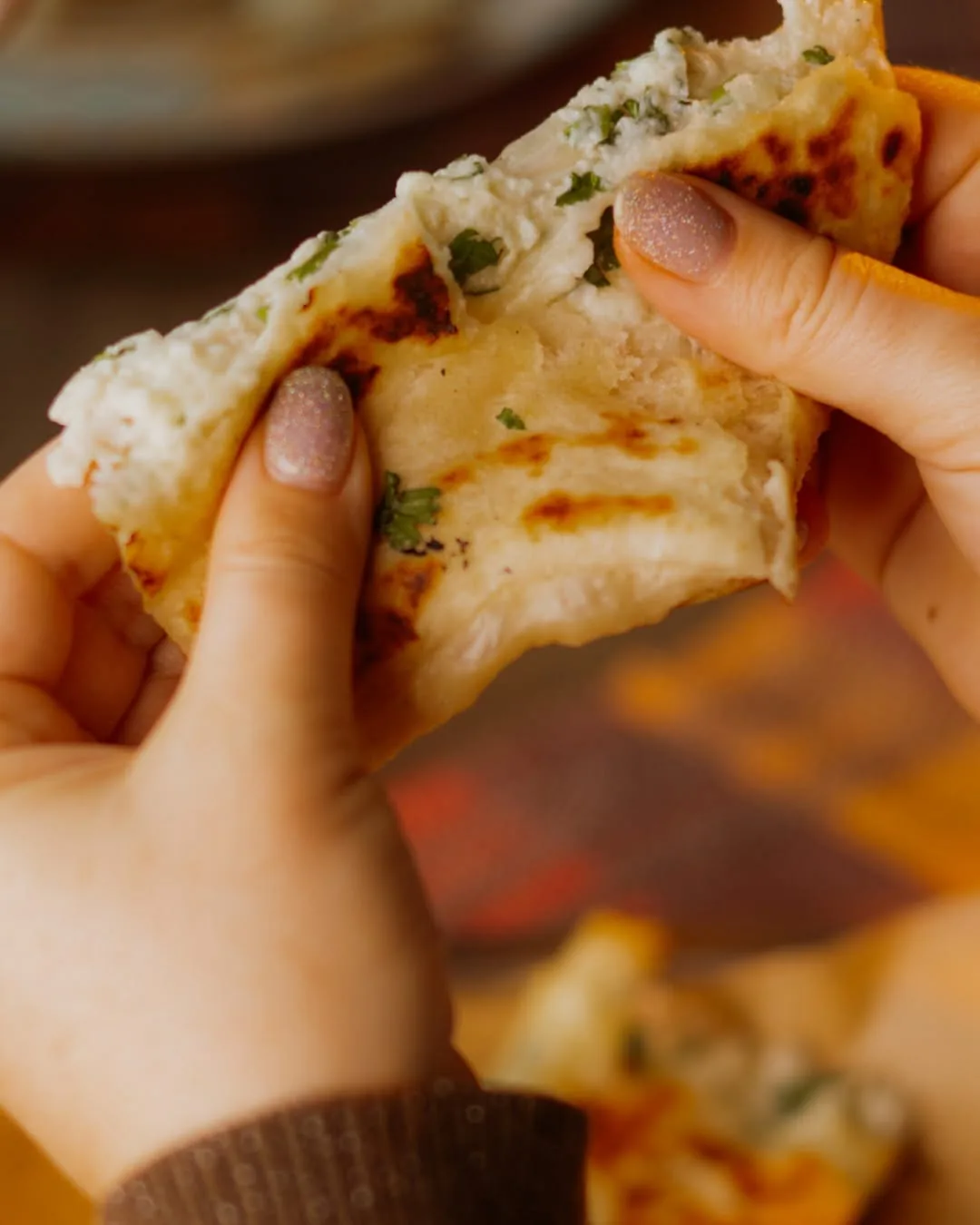Cheese naan rupt cu mâna, cu brânza întinzându-se